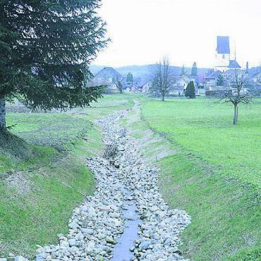 Noch voll im Zeitplan - Zwischen der Huemattenstrasse und dem Parkplatz beim Gemeindehaus wurde der Bach aus seinen unterirdischen Röhren befreit, er darf jetzt wieder munter Richtung Dorf plätschern. Bilder: Chregi Hansen