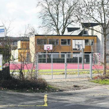 Baugesuch Junkholz-Turnhalle - Wenig Beeinträchtigung des schulischen Unterrichts während der Sanierungsarbeiten: Der Baustellenverkehr für die Sanierung der Junkholz-Turnhalle (im Hintergrund) wird über die Waltenschwilerstrasse (rechts von der Bushaltestation) geführt. Bild: Daniel Marti