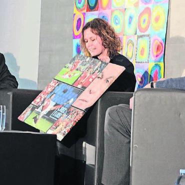 Viel Leidenschaft für den Beruf - Daniela Frutiger präsentiert Beispiele ihrer Arbeit als Sportfotografin. Links Moderator Jörg Meier, rechts der ehemalige Chefkoch des «Palace» in Gstaad, Hugo Weibel. Bild: Chregi Hansen