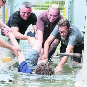 Mit Bestnote unter Wasser - Im Kirchenplatz-Brunnen wurde Joel Staubli von seinen Arbeitskollegen «gegautscht» und versenkt. Bilder: Stefan Sprenger