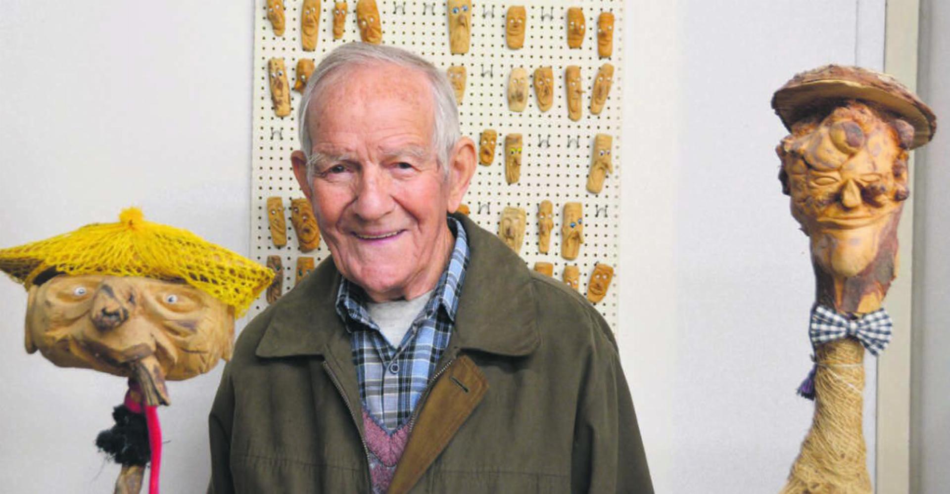 Der Künstler mit zwei grossen und ganz vielen kleinen Figuren: August Gauch umgeben von einer kleinen Auswahl seiner vielen Schnitzereien. Bild: Annemarie Keusch