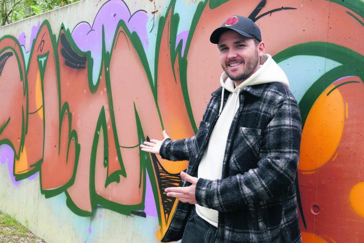 Alles so schön bunt hier: Cedric Wilhelm bei einem der Werke der Jugendlichen. Foto: Valentin Zumsteg
