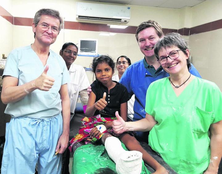 Patientin am zweiten Tag nach Klumpfuss-OP und nach Umgipsen: Dr. Ernst Orthner (ganz links), Dr. Dirk Thümmler (2. von rechts) und Veronika Gattermayr. Foto: zVg