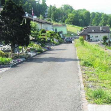 Wichtiger Erschliessungskredit - Diese Quartierstrasse soll verbreitert und die Leitungen darunter erneuert werden. Rechts hangabwärts entstehen gleichzeitig zehn Terrassenhäuser. Bild: zg