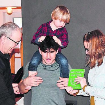 Dank Holz zum Wohlfühleffekt - Übergabe des Holzenergiepreises vor der modernen und klugen Hafnertec-Feuerung (v. l.): Stefan Staubli, Präsident von Holzenergie Freiamt, übergibt die Auszeichnung an die Familie Jasmin und Fabio Caduff mit Sohnemann Curdin. Bild: Daniel Marti