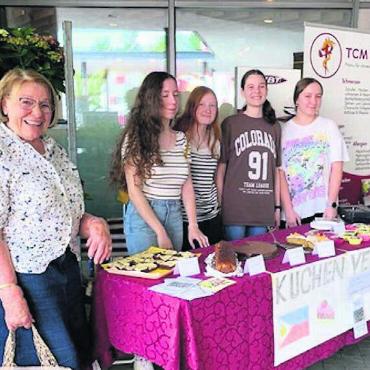 Kinder sammeln für Kinder - Die tüchtigen Mädchen, zusammen mit der Initiantin des Vereins Esther Bänziger, präsentieren am Verkaufsstand ihre Kuchen. Bild: zg