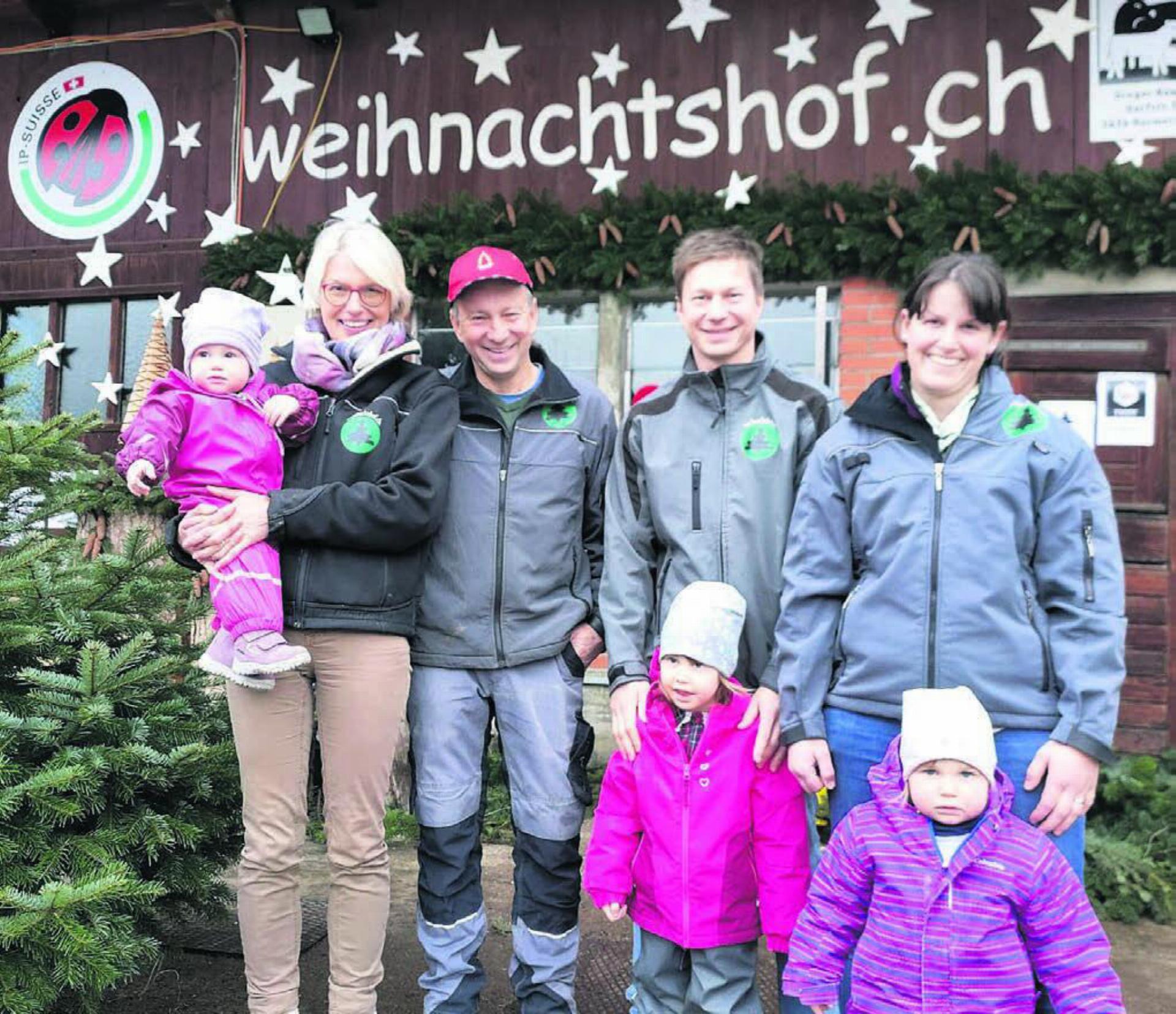 Gregor Keusch (mit der roten Mütze) und Frau Kathrin (links daneben) übergeben den Weihnachtshof an Roman Keusch mit Frau Karin und den Kindern Bianca, Leonie und Livia. Bild: Marco Huwyler