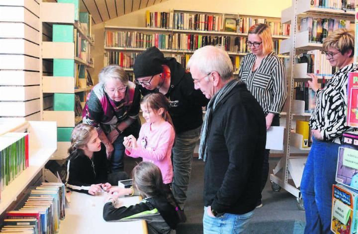 Was wollen uns diese Würfel wohl sagen? Wie müssen sie angeordnet werden? Und was bedeuten die Zahlen und Buchstaben? Gleich drei Generationen rätselten sich bei der Sarmenstorfer Premiere durch das Abenteuer. Beobachtet wurden sie dabei durch Bibliotheksleiterin Christina Eppisser und Spielentwicklerin Anita Abt (von rechts). Bilder: Chregi Hansen
