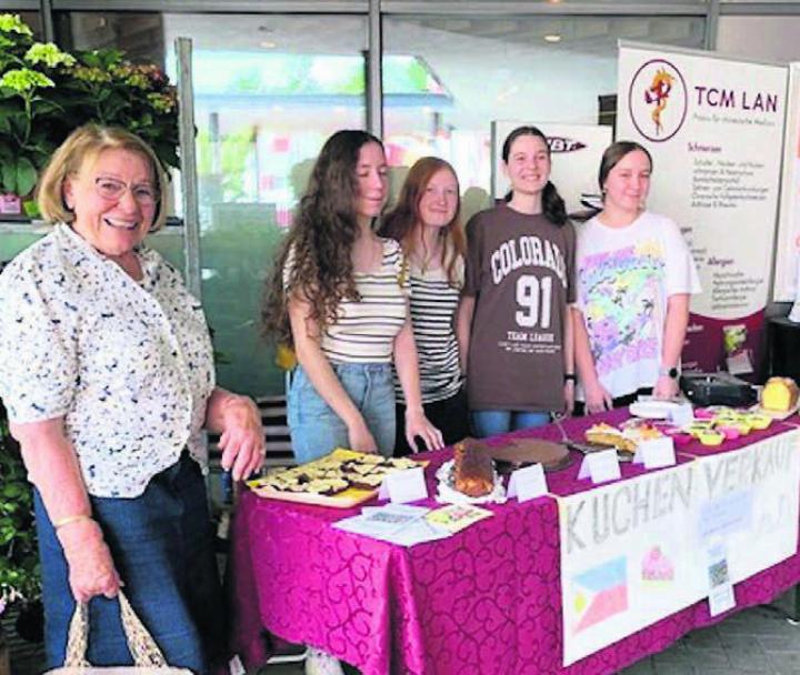 Die tüchtigen Mädchen, zusammen mit der Initiantin des Vereins Esther Bänziger, präsentieren am Verkaufsstand ihre Kuchen. Bild: zg