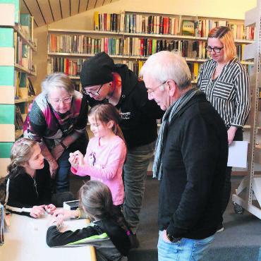 Die Bibliothek neu entdecken - Was wollen uns diese Würfel wohl sagen? Wie müssen sie angeordnet werden? Und was bedeuten die Zahlen und Buchstaben? Gleich drei Generationen rätselten sich bei der Sarmenstorfer Premiere durch das Abenteuer. Beobachtet wurden sie dabei durch Bibliotheksleiterin Christina Eppisser und Spielentwicklerin Anita Abt (von rechts). Bilder: Chregi Hansen