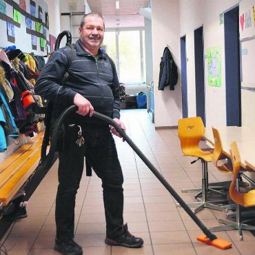 Der Mann für alle Fälle - In den Gängen des Schulhauses mit dem Rucksackstaubsauger unterwegs – so ist Heinz Rosenberg in seinem Alltag als Hauswart öfters anzutreffen. Bild: Annemarie Keusch