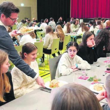 Bei Wasser und Reis sitzen - Ein doch etwas neidischer Blick von der Nachbarin ist zu erkennen, als das leckere Pastetli von Schulleiter Fabian Bühler serviert wird. Bilder: Susanne Schild