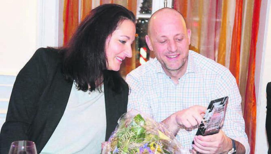 Martin Laubacher und Freundin Sandra Passerini begutachten den Pokal, den der langjährige Präsident von Handball Wohlen überreicht bekam.